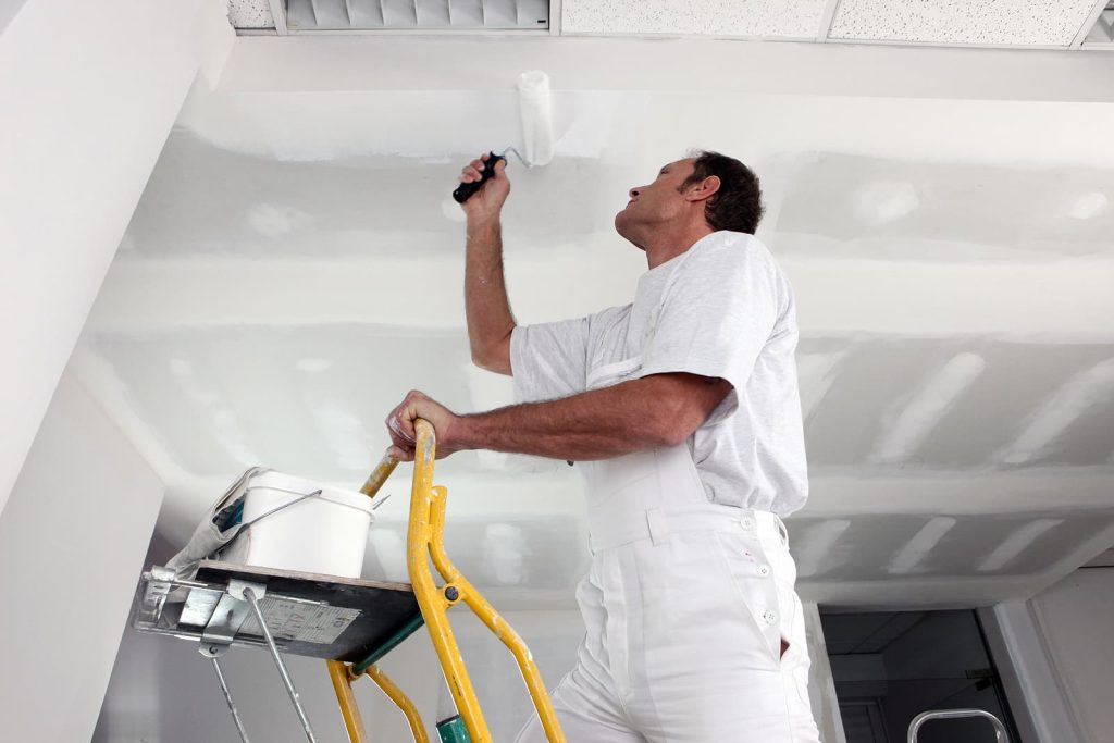 bespoke refurbishment - Tradesman painting a ceiling